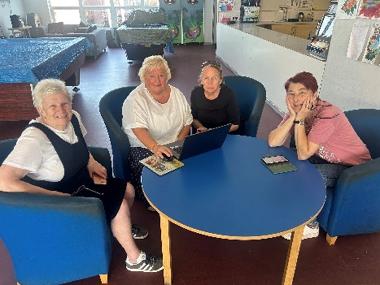 four women with digital devices